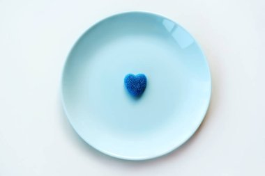 Blue lonely marmalade sugar heart on a light blue pastel plate