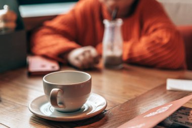 Girl teenager sitting in a cafe at a table waiting 