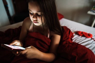 Portre yapmak ve sanal mesaj göndermek için cep telefonu kullanan kız