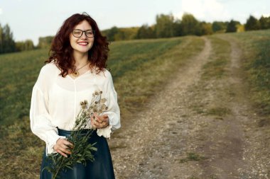 Yüzünde kırmızı kıvırcık saçlı ve çiller ile güzel genç kadın.