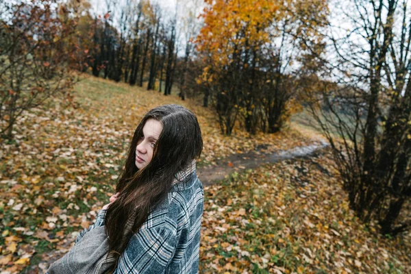 Red-headed freckled girl in autumn yellow park. The first snow, wet rain. — Stock Photo, Image