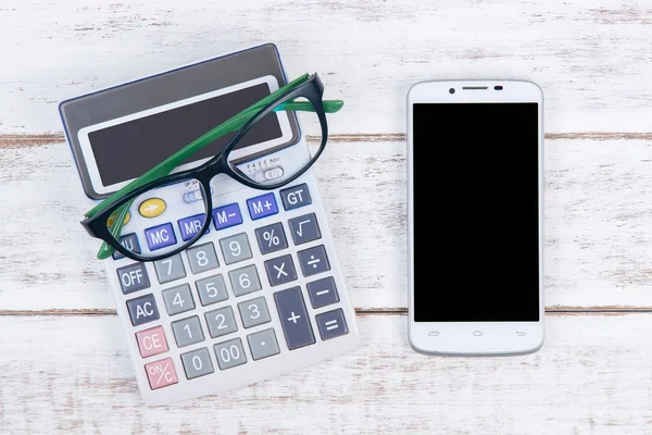 Вид калькулятора, очков и смартфона сверху — стоковое фото