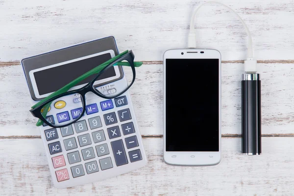 Vista superior da calculadora, óculos e smartphone no contador — Fotografia de Stock