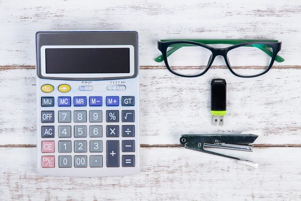 Вид сверху на калькулятор и очки на белом столе — стоковое фото