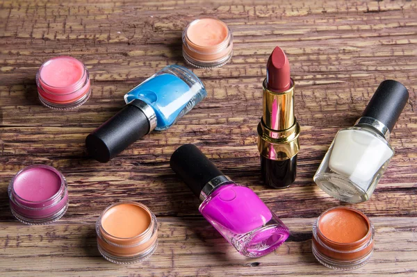 Group of bright nail polishes and lipstick on brown wood — Φωτογραφία Αρχείου