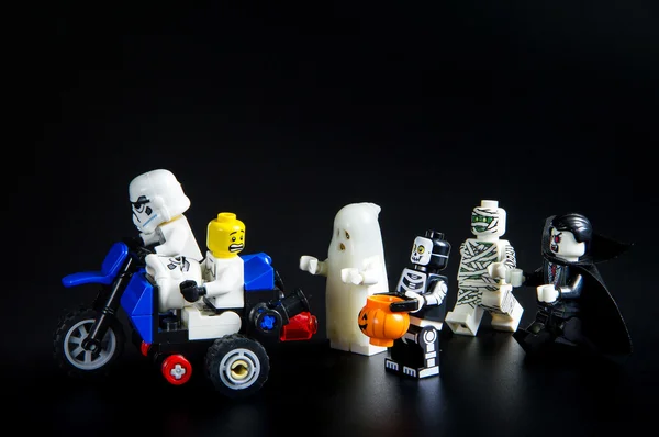 Lego star wars stormtrooper rijden op een motorfiets wegrennen ghost halloween. Thema Halloween achtergrond. — Stockfoto