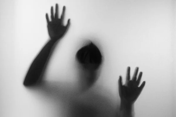 Horror woman behind the matte glass in black and white. Blurry h — Stock Photo, Image