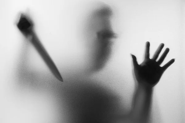 Horror Murderer. Dangerous man behind the frosted glass with a k — Stock Photo, Image