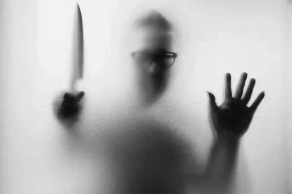 Assassino de terror. Homem perigoso atrás do vidro fosco com um k — Fotografia de Stock