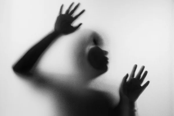 Mulher de terror atrás do vidro fosco em preto e branco. Desfoque h — Fotografia de Stock