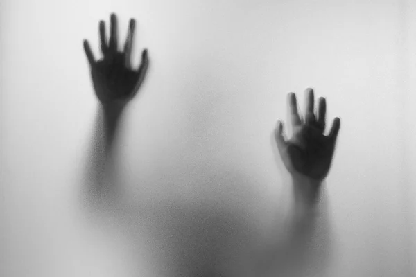 Les mains d'ombre de l'homme derrière le verre givré. — Photo