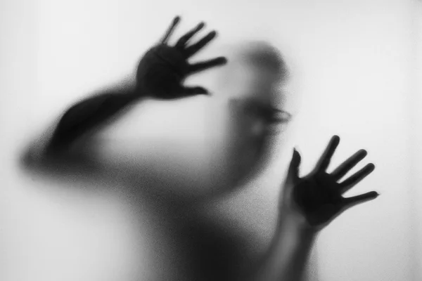 Horror férfi mögött fekete-fehér matt üveg. Foltos han — Stock Fotó