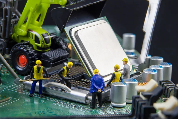 Equipo de juguetes minúsculos de ingenieros que reparan la compu de la placa madre del circuito —  Fotos de Stock