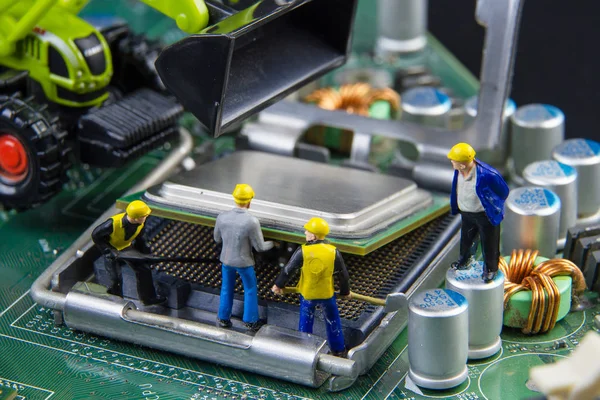 Equipo de juguetes minúsculos de ingenieros que reparan la compu de la placa madre del circuito —  Fotos de Stock