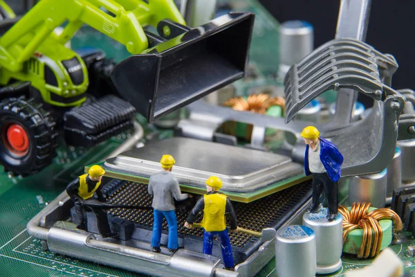 Equipo de juguetes minúsculos de ingenieros que reparan la compu de la placa madre del circuito —  Fotos de Stock