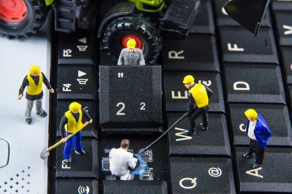 Equipe de brinquedos minúsculos de engenheiros que reparam computador portátil do teclado. — Fotografia de Stock