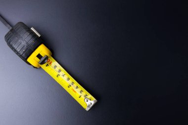 Ölçüm bandı İnşaat aletleri lig siyah bir zemin üzerine