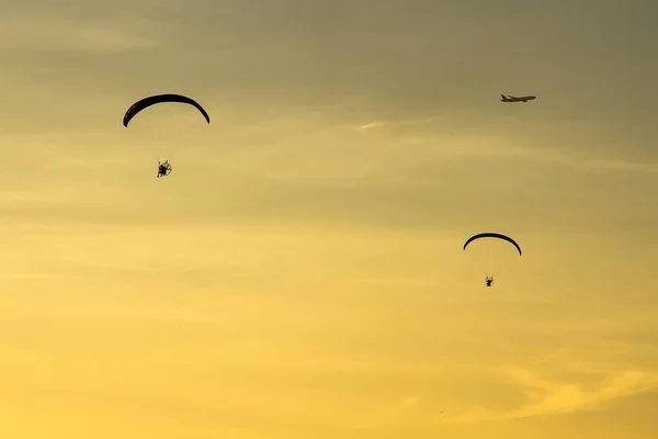 Silhouette Paramotor, fallskärm, paraglida flyger i solnedgången — Stockfoto