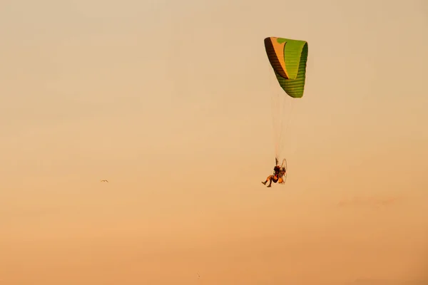 Silhouet Paramotor, Parachute, paragliden vliegen in de zonsondergang — Stockfoto