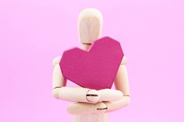 Kağıt kutusu kırmızı kalp şekli üzerinde pembe adam tutarak ahşap kukla
