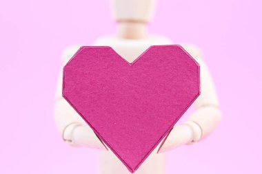 Kağıt kutusu kırmızı kalp şekli üzerinde pembe adam tutarak ahşap kukla