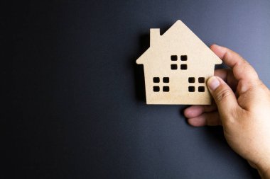 Adamın elini tutmak ahşap ev oyuncak polis siyah zemin üzerine