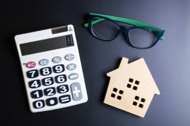 Ahşap ev oyuncak ve hesap makinesi siyah zemin üzerine sp kopyalayın