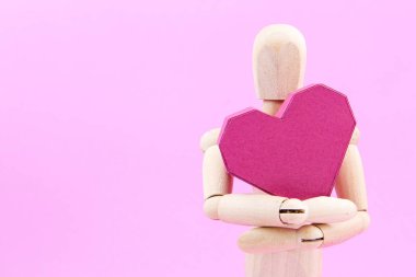Kağıt kutusu kırmızı kalp şekli üzerinde pembe adam tutarak ahşap kukla