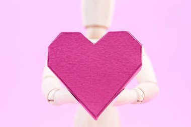 Kağıt kutusu kırmızı kalp şekli üzerinde pembe adam tutarak ahşap kukla