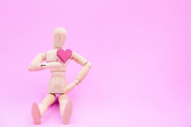 Kalp ahşap kukla ve bir kağıt kutu kırmızı pembe bir arka plan üzerinde şekil 