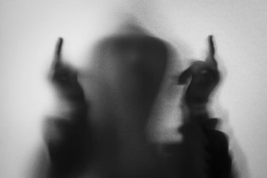 Gölge bulanıklık korku adamın kukuleta ile ceketli. Orta parmak symb