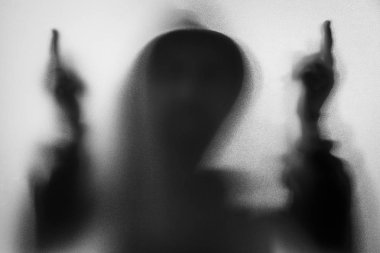 Gölge bulanıklık korku adamın kukuleta ile ceketli. Orta parmak symb