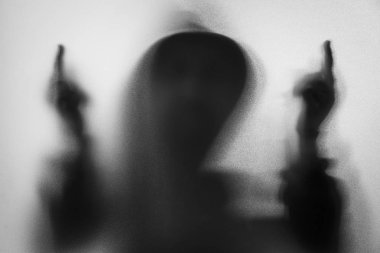 Gölge bulanıklık korku adamın kukuleta ile ceketli. Orta parmak symb