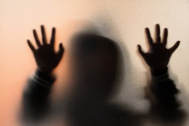 Gölge bulanıklık korku adamın kukuleta ile ceketli. Eller camına