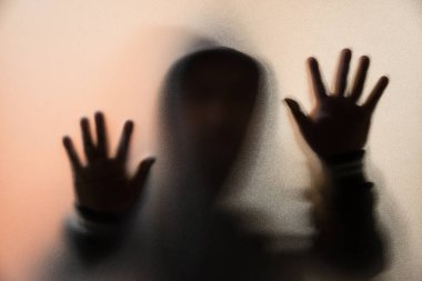 Gölge bulanıklık korku adamın kukuleta ile ceketli. Eller camına