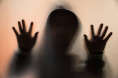 Gölge bulanıklık korku adamın kukuleta ile ceketli. Eller camına