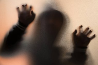 Gölge bulanıklık korku adamın kukuleta ile ceketli. Eller camına