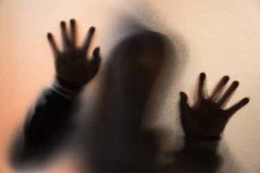 Gölge bulanıklık korku adamın kukuleta ile ceketli. Eller camına