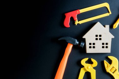 Ahşap ev oyuncak ve inşaat araçları oyuncak siyah arka plan üzerine 