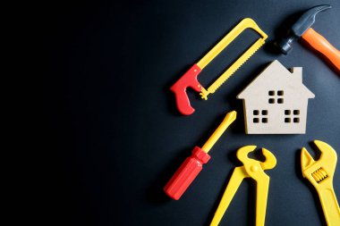 Ahşap ev oyuncak ve inşaat araçları oyuncak siyah arka plan üzerine 