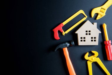 Ahşap ev oyuncak ve inşaat araçları oyuncak siyah arka plan üzerine 