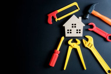 Ahşap ev oyuncak ve inşaat araçları oyuncak siyah arka plan üzerine 