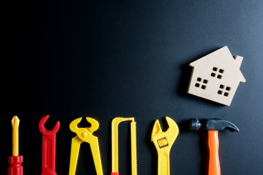 Ahşap ev oyuncak ve inşaat araçları oyuncak siyah arka plan üzerine 
