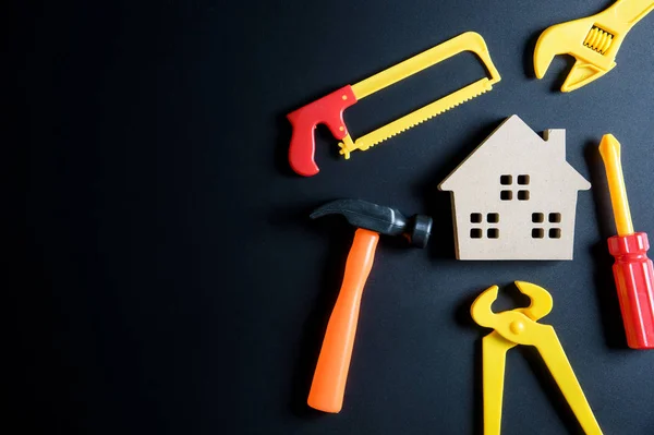 Juguete de casa de madera y juguete de herramientas de construcción sobre fondo negro — Foto de Stock