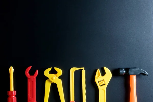 Juguete de herramientas de construcción sobre fondo negro con espacio de copia. — Foto de Stock