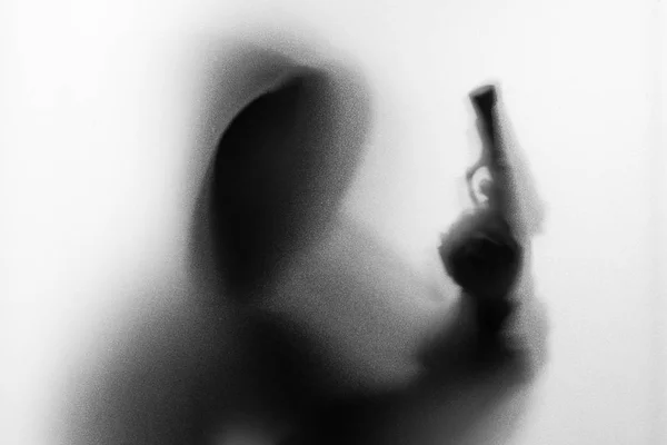 Ombre flou de l'horreur homme en veste avec pistolet à capuche dans sa main.Da — Photo
