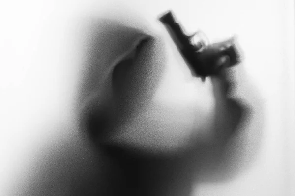 Rozostření stínu člověka horor v bundě s kapucí pistolí v ruce. Da — Stock fotografie