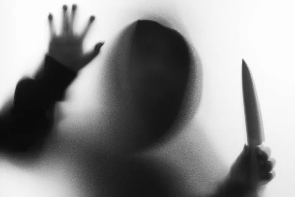 阴影模糊的恐怖男人穿夹克罩刀在他的手. — 图库照片