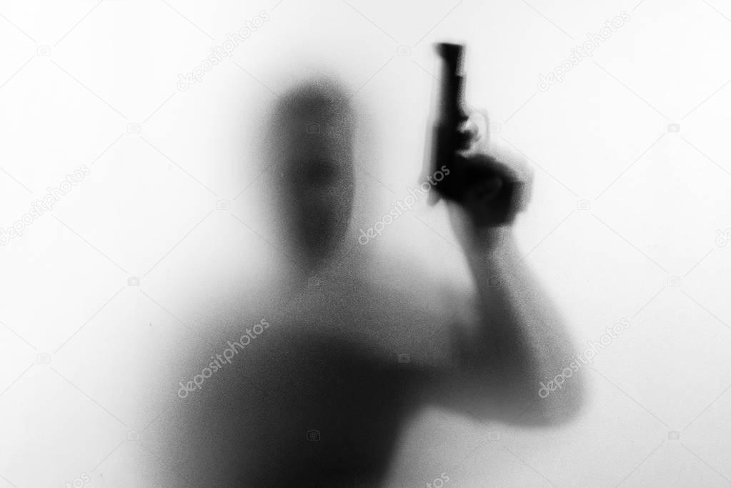 Shadow of horror man killer with a gun in his hand.Dangerous man