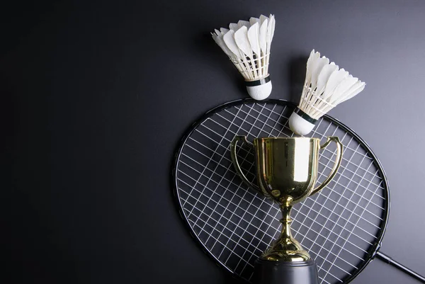 Trofeo dorado, Shuttlecocks y raqueta de bádminton sobre fondo negro — Foto de Stock